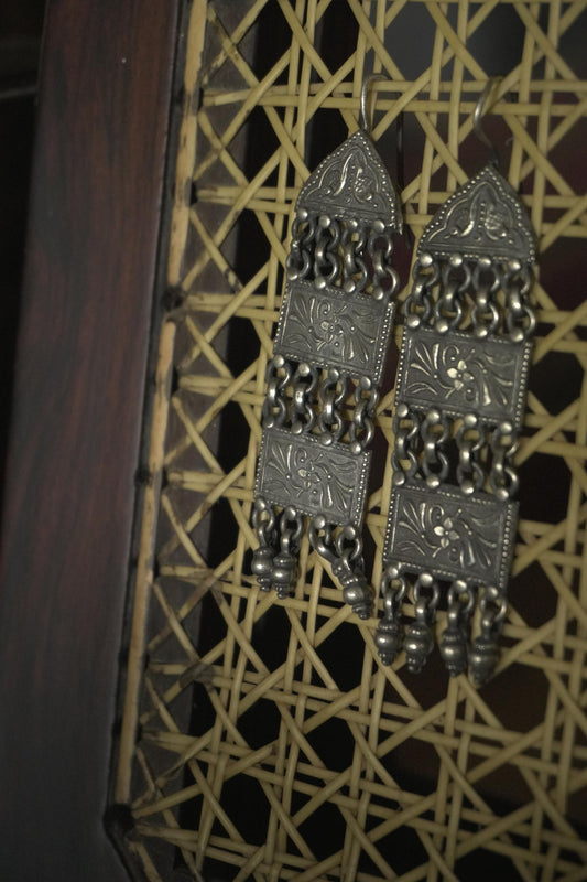 Tribal silver jewellery Sharana earrings in 92.5 silver with intricate etched design and dangling charms.