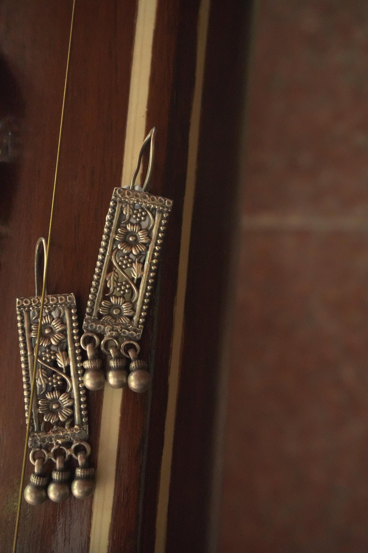 Rectangular tribal silver jewellery earrings in 92.5 silver with intricate detailing and dangling silver beads.