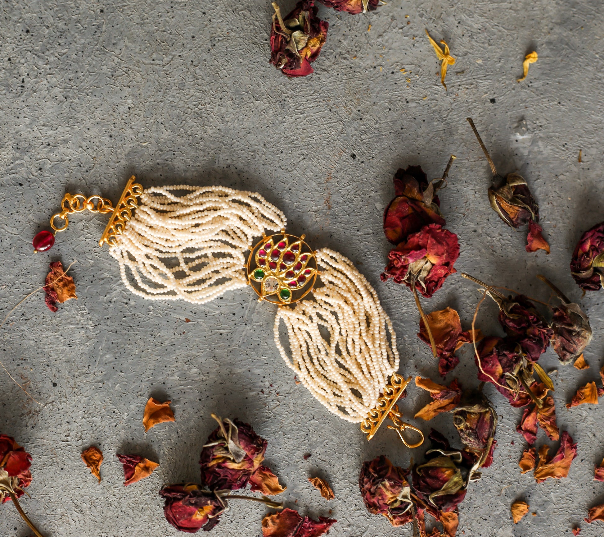 Kai Bracelet - handcrafted sterling silver bracelet with 22ct gold leaf, featuring lotus motif in red kemp stones and white pearl strands
