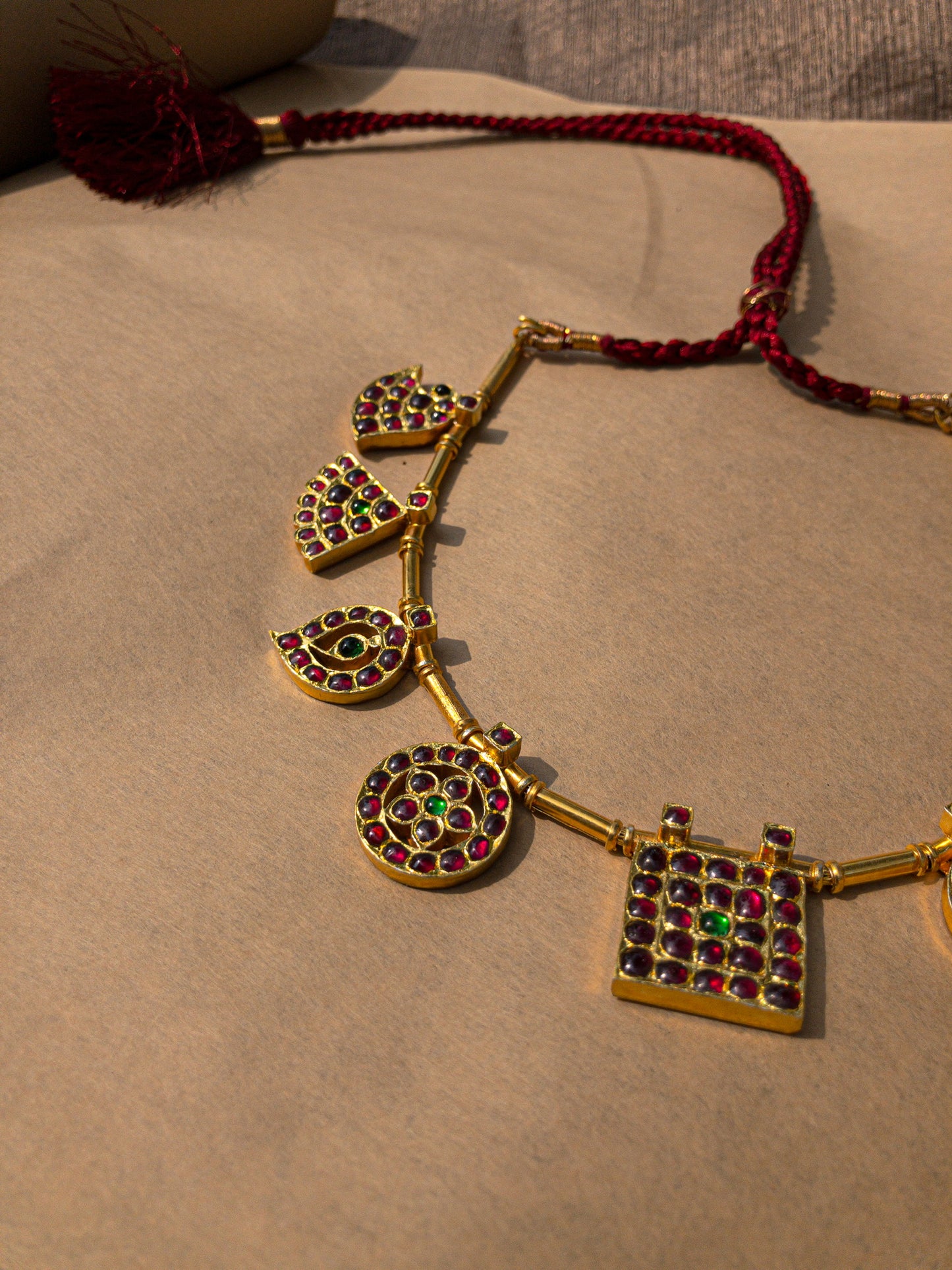 Side view of Raani Maalai necklace displaying five royal pendant motifs in traditional gold finish