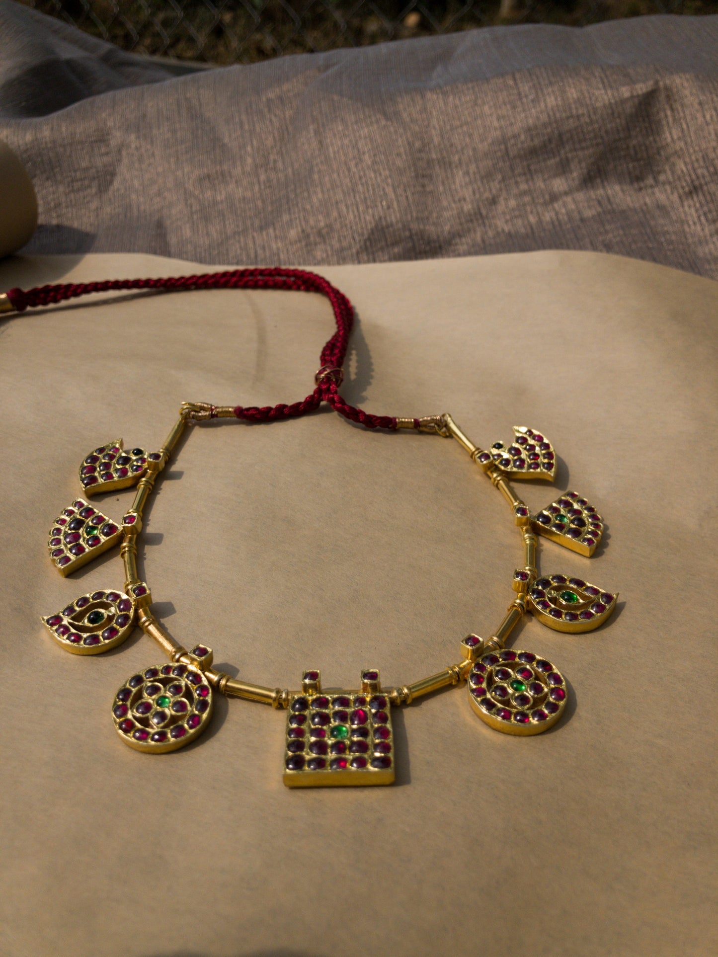 Side view of Raani Maalai necklace displaying five royal pendant motifs in traditional gold finish
