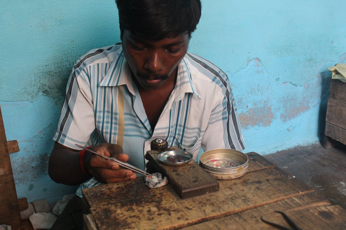 A silversmith setting kemp stones by hand at his workbench