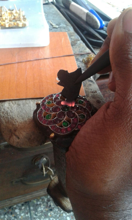 An artisan soldering red kemp stones into a gilded setting, Vadasery, Nagercoil