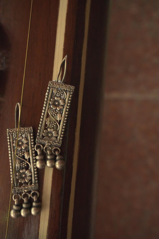 Rectangular tribal silver jewellery earrings in 92.5 silver with intricate detailing and dangling silver beads.