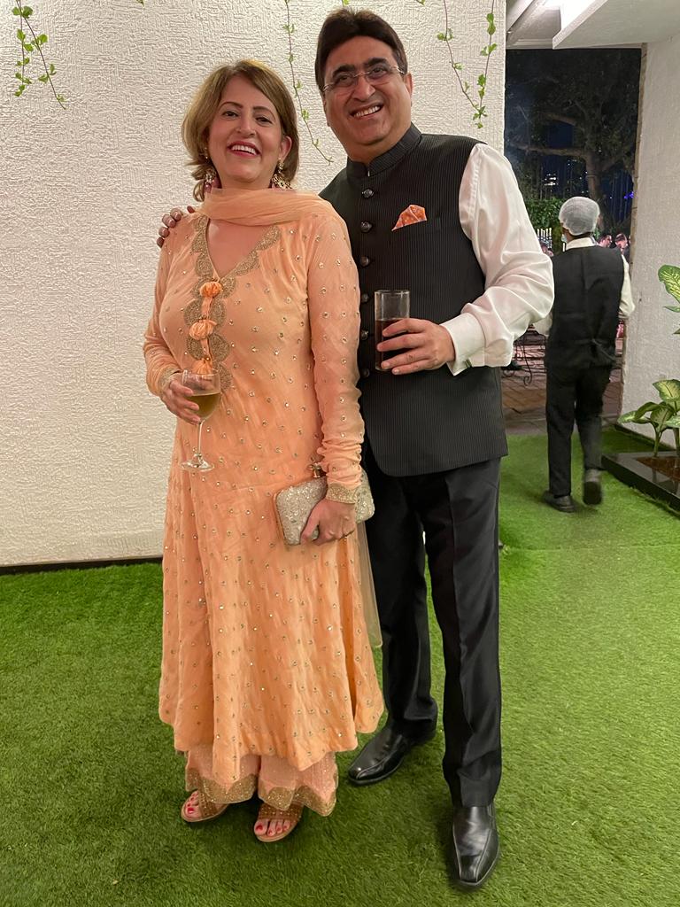 Woman wearing Abharika temple earrings with peach embellished suit at formal party event - elegant evening jewelry styling