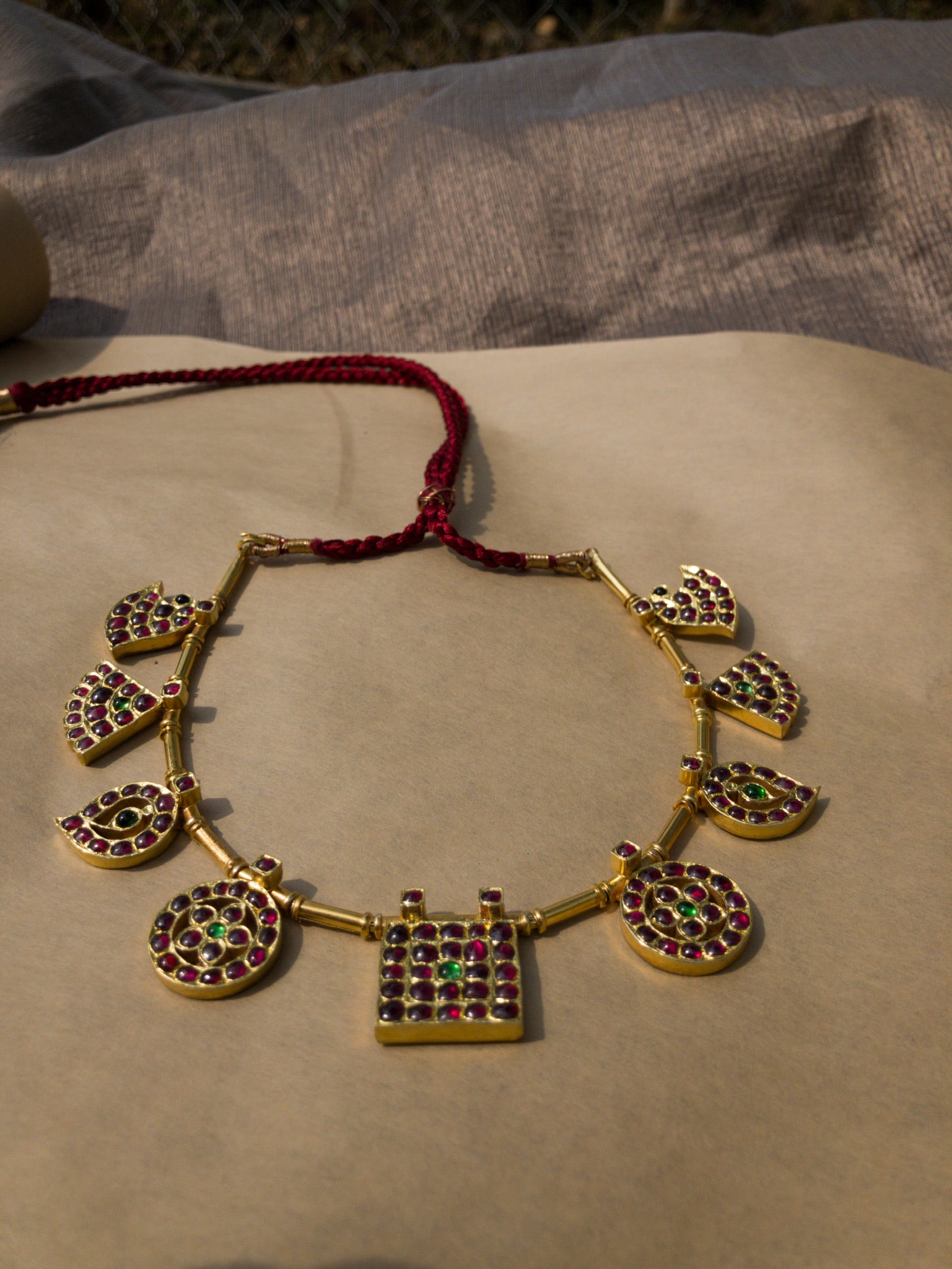 Side view of Raani Maalai necklace displaying five royal pendant motifs in traditional gold finish