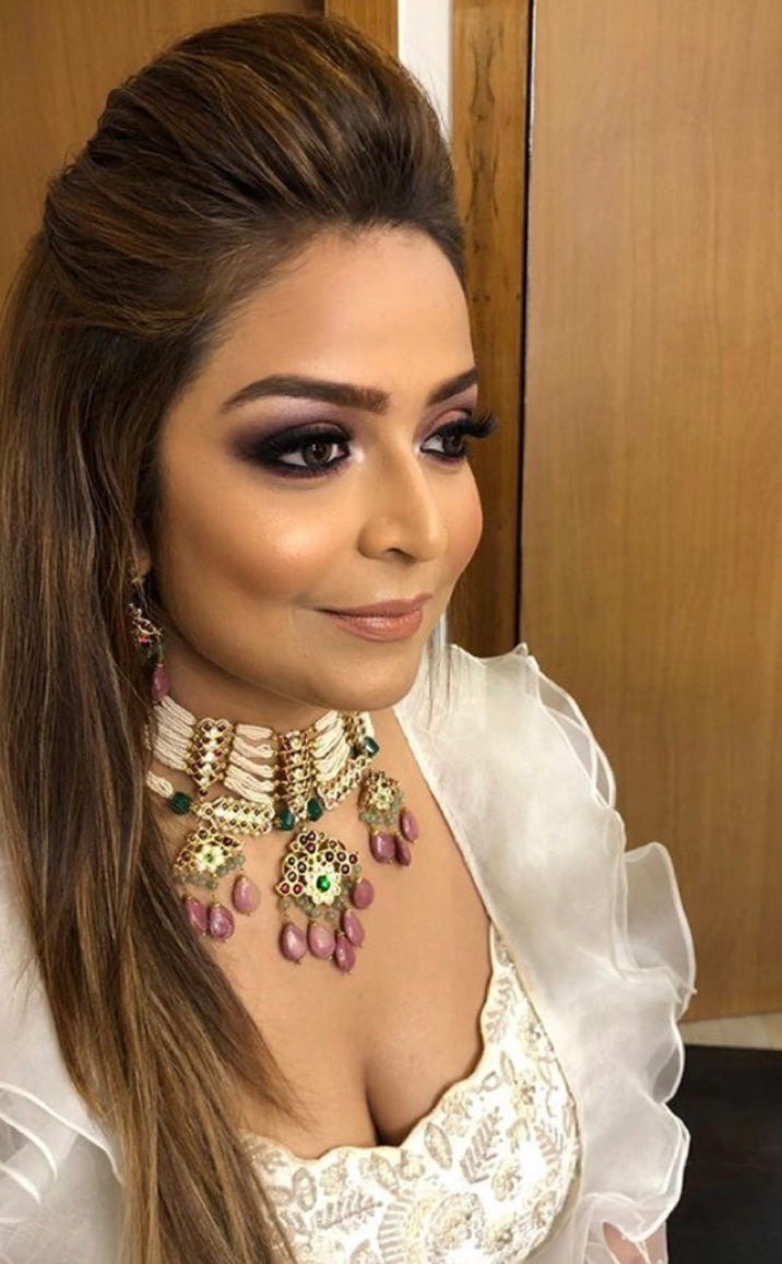 Client wearing Abharika necklace with white embroidered outfit and glamorous makeup - showcasing temple jewelry for special occasion styling