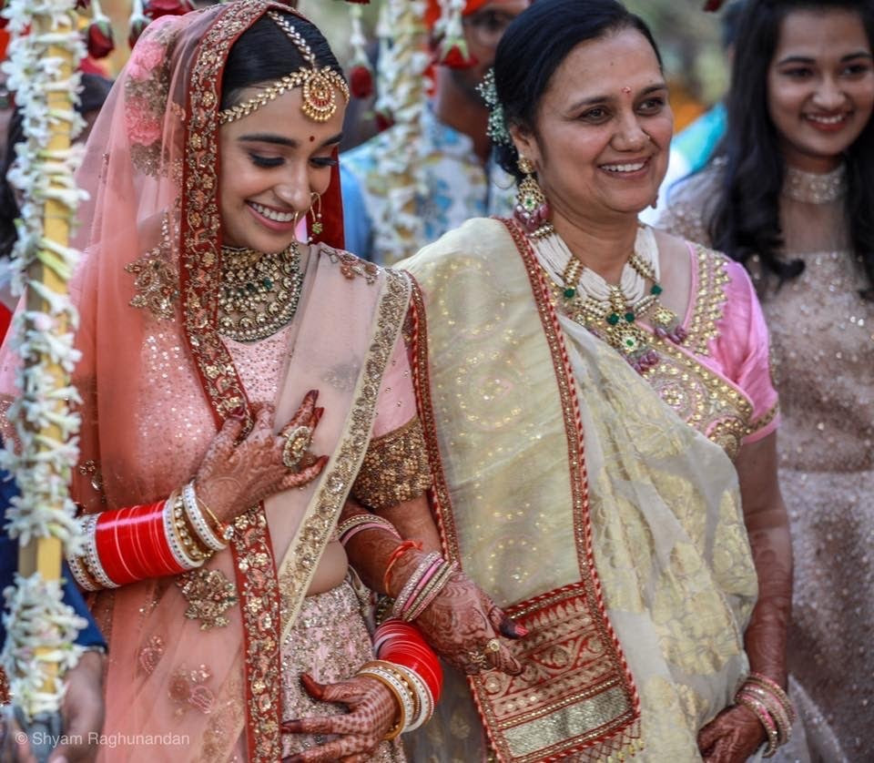 Mother of bride wearing Abharika temple necklace by Aaharya at Indian wedding ceremony 