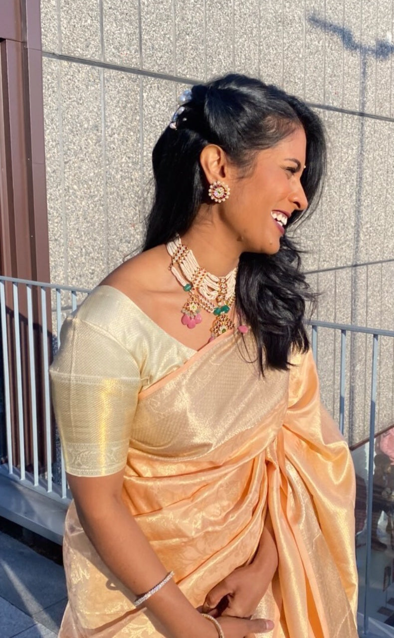 Woman wearing Abharika temple necklace with golden silk saree and traditional kundan earrings - lifestyle shot showing festive styling