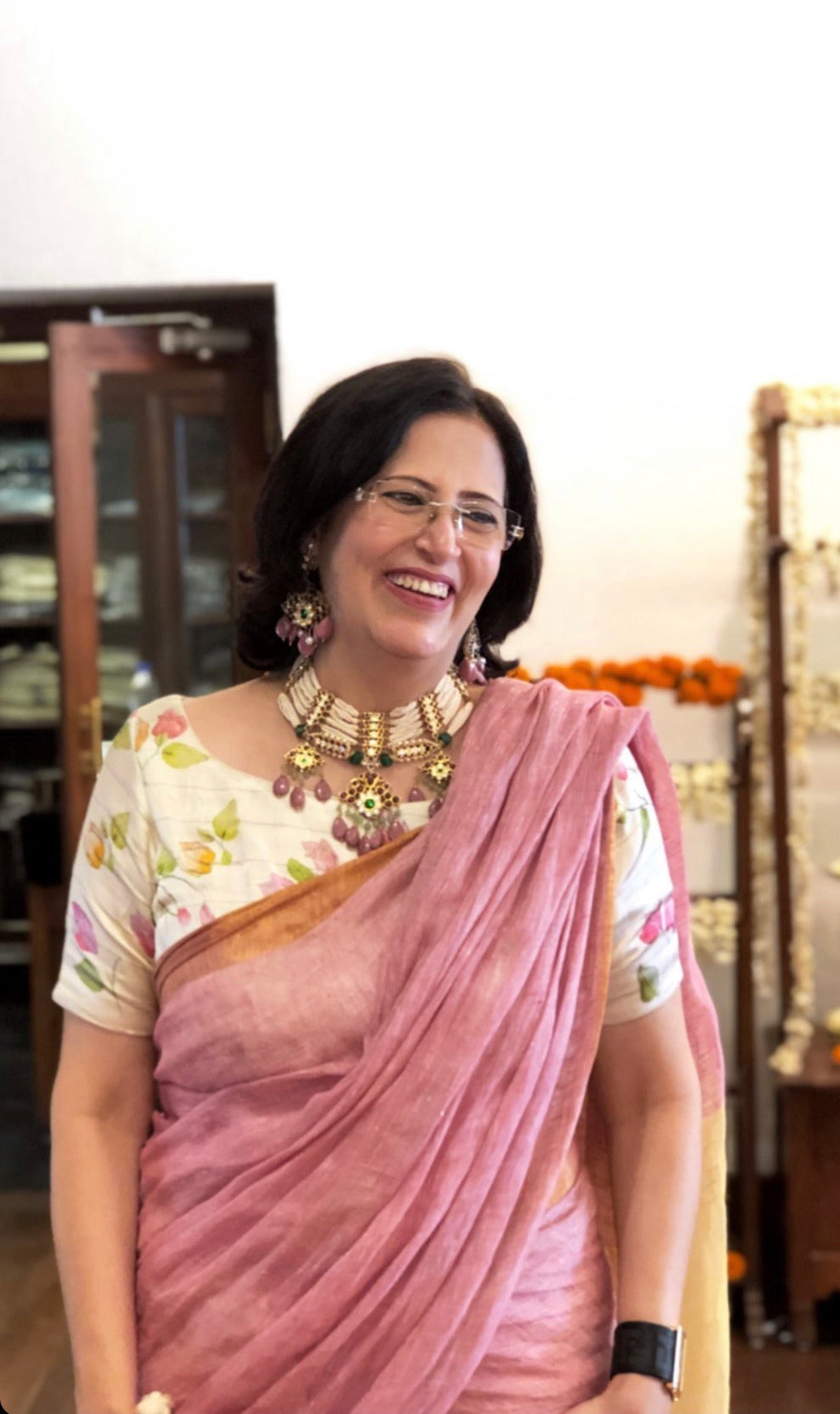 Woman in pink saree wearing Abharika temple necklace with red kemp stones and matching traditional earrings by Aaharya